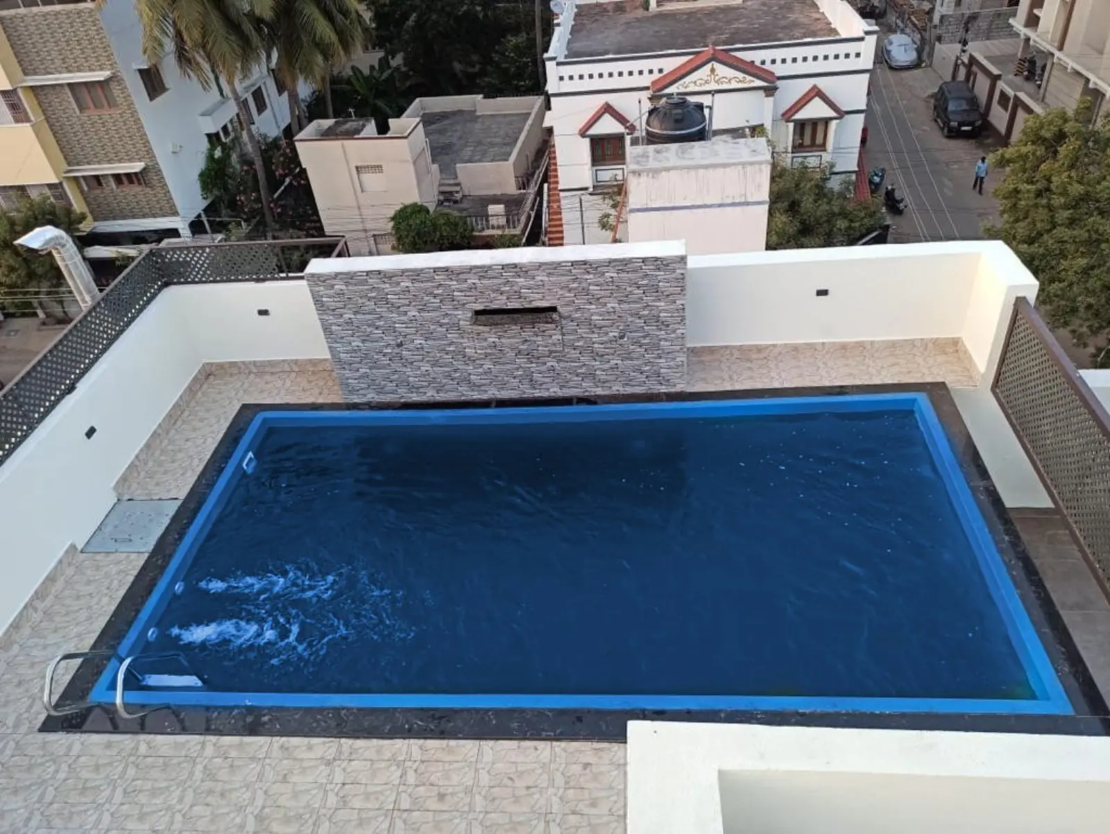 Rectangular rooftop vinyl liner pool with dark stone coping by CreativPools