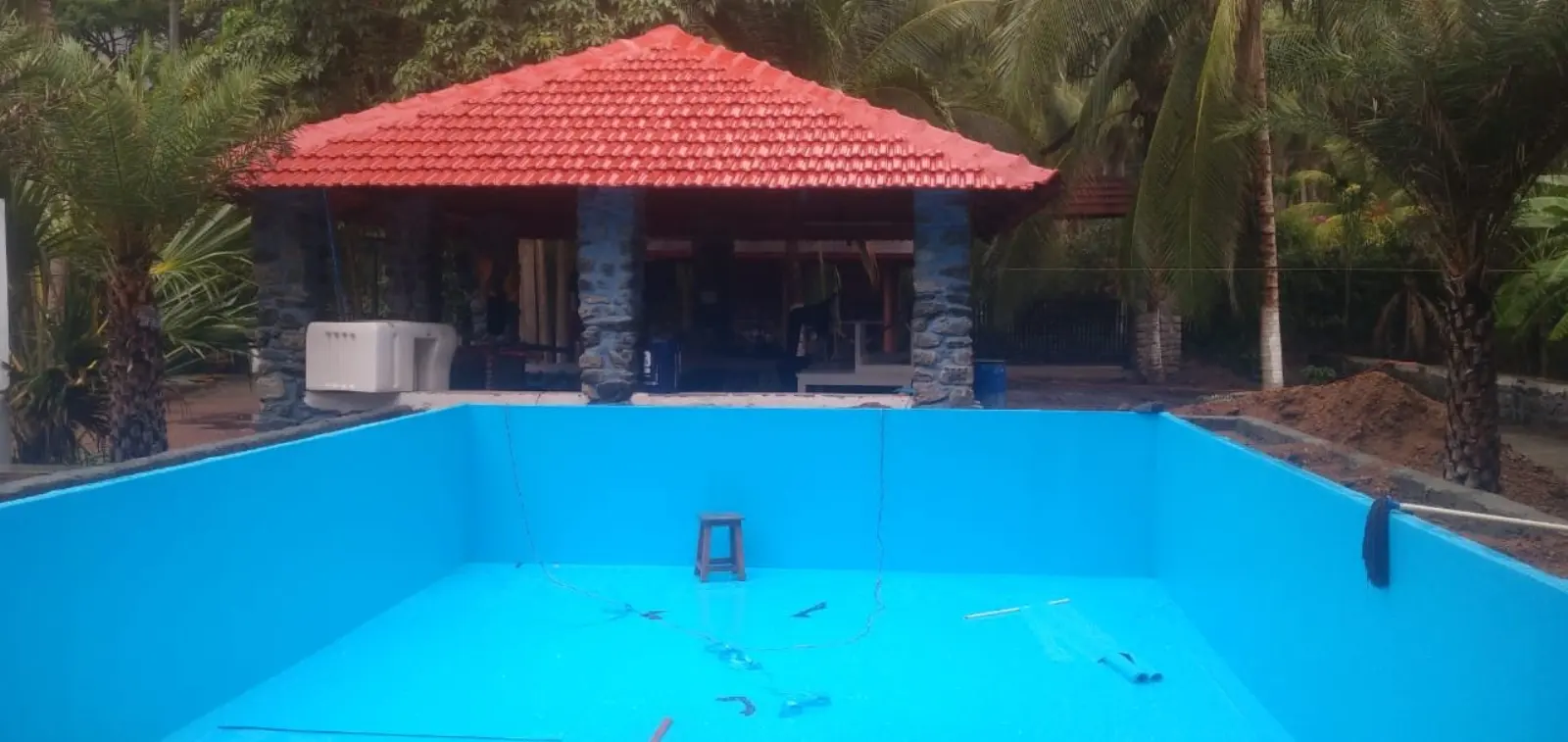 Membrane-lined pool under construction beside a tiled-roof pavilion — CreativPools